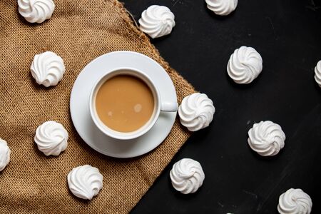 White cup of coffee and meringue on dark backgroundの写真素材