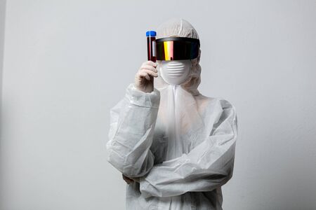 Doctor in protection clothes holds COVID-19 vaccine