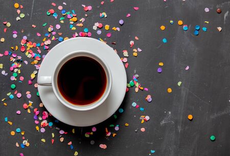 Cup of coffee and confetti on a tableの写真素材