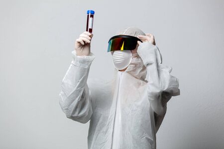 Doctor in protection clothes holds COVID-19 vaccineの写真素材