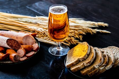 glass of beer, sausages and bread on the tableの写真素材