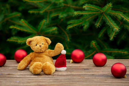 cup of coffee and teddy bear on wooden table with spruce branches on backgroundの写真素材