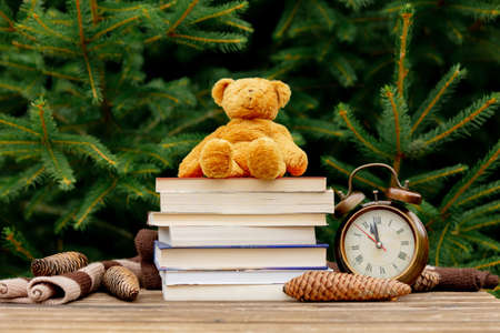 Cup of coffee and books with Santa Claus hat on wooden table