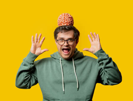 Guy in green hoodie with brain on yellow backgroundの写真素材