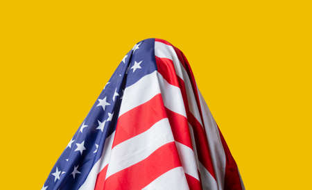 guy with USA flag on head on yellow background