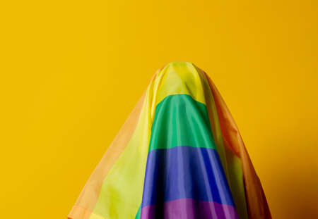 Guy with LGBT flag on head on yellow backgroundの写真素材
