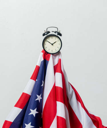 USA flag and alarm clock on white backgroundの写真素材