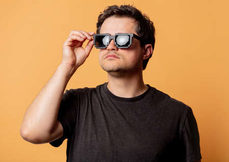 Man in style sunglasses on yellow background