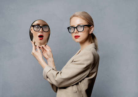 Style blonde with mirror on gray background