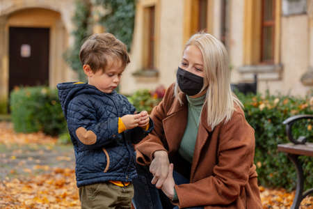 mather and son are playing in the park in autumnの写真素材
