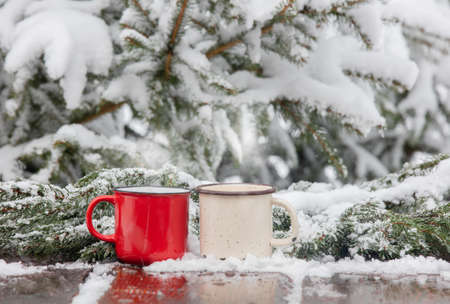 two cups of coffee on wooden table in snowの写真素材