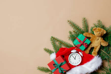 Holiday gift boxes with spruce branches and teddy bear with alarm clock on stark white color background. Above viewの写真素材