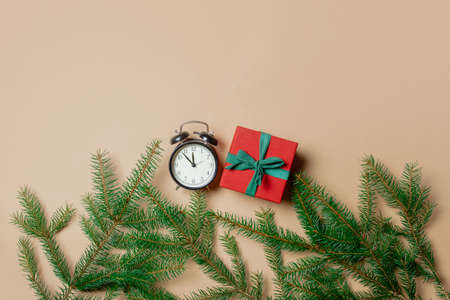 Holiday gift box with spruce branches and alarm clock on stark white color background. Above viewの写真素材