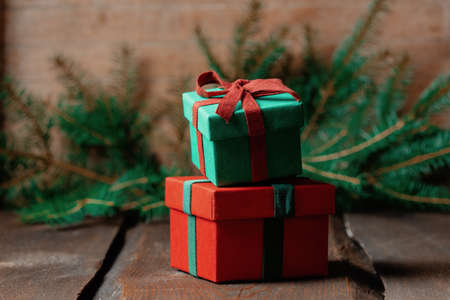 Christmas gift boxes and spruce branch on wooden table