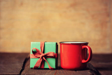 Cup of coffee and gift box on wooden table.の写真素材