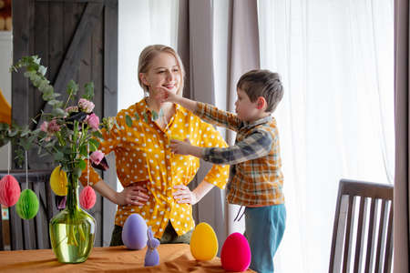 mother and son are decorating a table with paper eggs for Easter. Indoorの写真素材