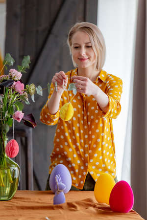 Female is decorating a table with paper eggs for Easter. Indoorの写真素材