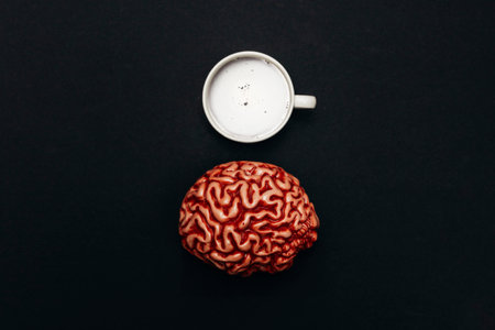 cup of coffee with a decorative human brain on a black background, top view, concept of creativity and thinkingの写真素材