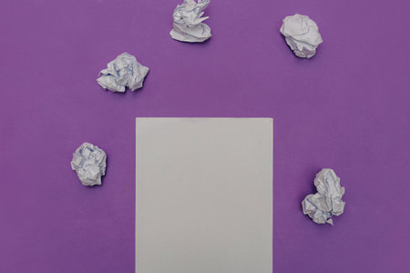 Crumpled paper and white sheet of paper on violet background, top view.の写真素材