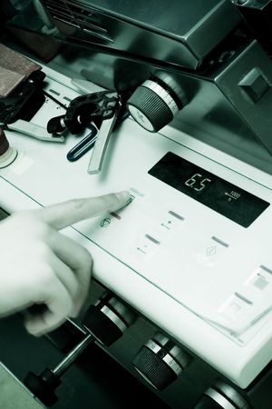 Operator pushing a button on an Offset Printing Machine in print shop