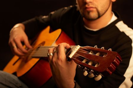 Rock star plays acoustic guitar on stage with great lights