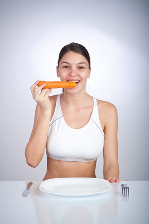 Woman biting a carrotの写真素材