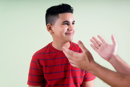 Happy latin preteen smiling to his affectionate fatherの写真素材