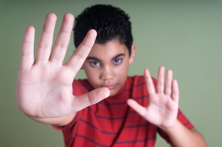 Scared latin boy making a stop gestureの写真素材