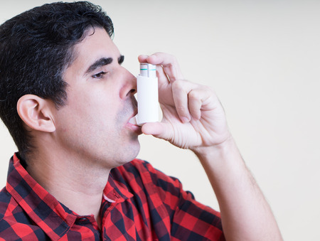 Hispanic man using an inhalerの写真素材