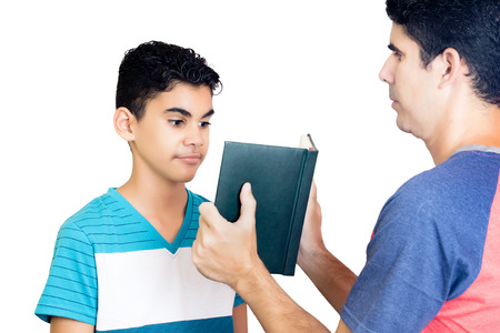 Hispanic father show their diary to his surprised son isolated on white.の写真素材