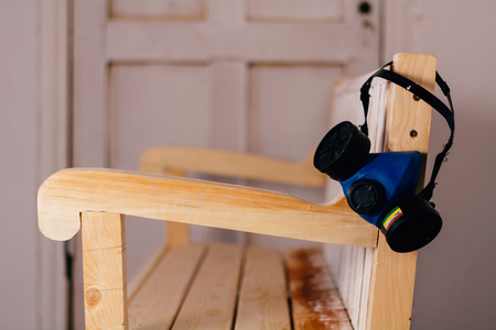 The respirator hangs on the back of a painted benchの写真素材