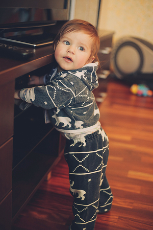 Little boy standing in the living room near the TVの写真素材
