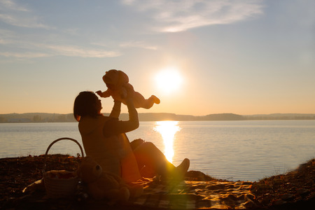 Mom and daughter in the evening playing on the beachの写真素材