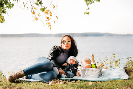Brunette girl with a small child playing on the shore of the blue seaの写真素材
