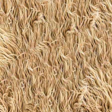 Close-up of a yellow-brown furry rug.Texture or backgroundの写真素材