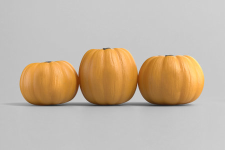 Three yellow pumpkins on a gray backgroundの写真素材