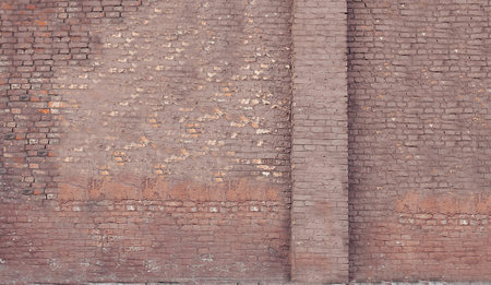 An old red brick wall in the middle plan on the streetの写真素材