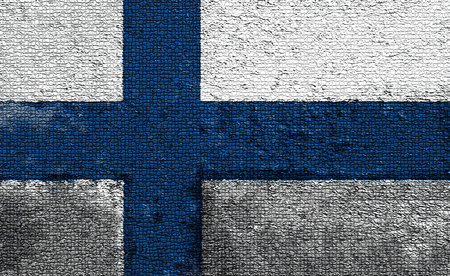 Finnish flag is waving proudly on a textured wallの写真素材