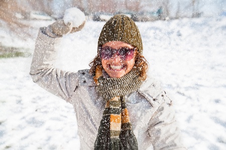 Happy young woman playing snowball fight on the snow  day   Winter concept の写真素材