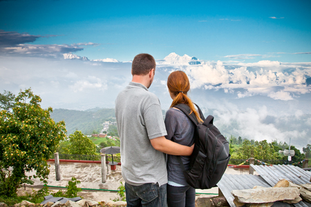 Young couple watching ascend Mount Everest in the early morning, the Himalayas, Nepal. Young people traveling in Asia, trekkers on trail in wilderness.の写真素材