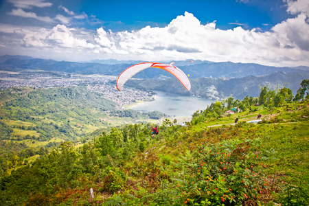 POKHARA, NEPAL -MAY 25, 2013: Paraglider Paragliders take off from Sarangkot on May 25, 2013 in Pokhara, Nepal.The main area for paragliding in Nepal is Sarangkot, Pokhara valley.のeditorial素材