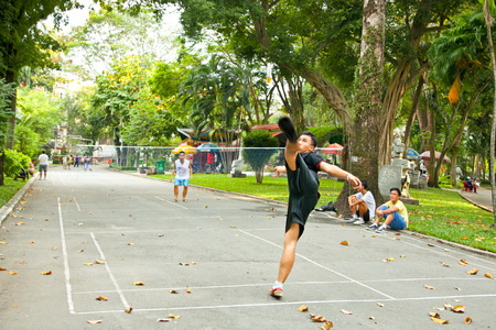 HO CHI MINH, VIETNAM-NOVEMBER 17. 2013: Men plays badminton using feet (footbag) in Tao Dan Park on Noveber 17, 2013, Saigon, Vietnam. のeditorial素材