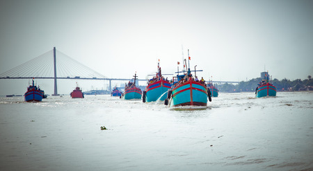 FIshing boats returning from fishing in the port of the Mekong Delta, Vietnam.の写真素材