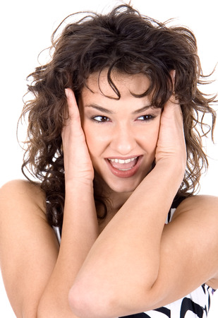 Beautiful young brunette hold on a face with handsの写真素材