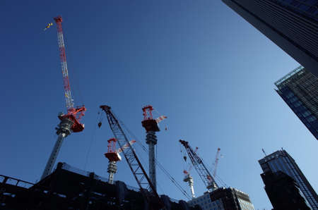 Building Cranes against Blue Sky
