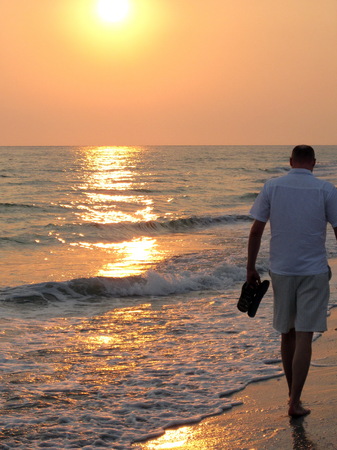 man walking on beach into sunset on sanibel islandの写真素材