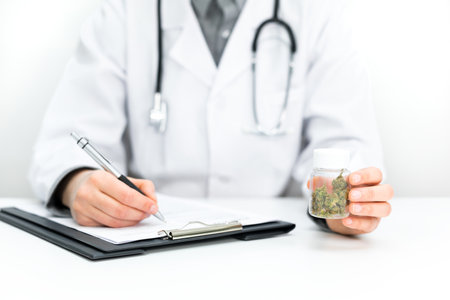 Doctor prescribes CBD for pain relief and healing. Doc holds medical marijuana in hand, offers medical cannabis, legal light medication, alternative remedies or medicines, medicine concept to patientの写真素材