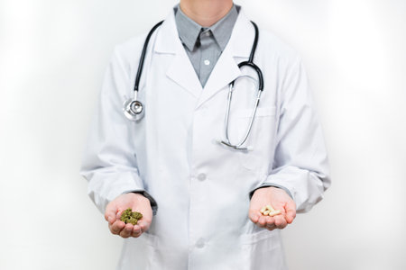 Doctor with medical cannabidiol CBD cannabis capsule with white background. Alternative, natural, legal medicine for pain. Herbal medication. Legal marijuana for healthcare.の写真素材