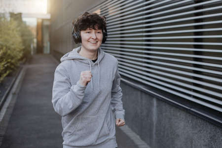 young person runs and makes fitness workout for good health and listing to music on earphonesの写真素材