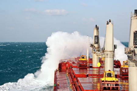 Movement of the vessel in stormy weather, Pacific Ocean. Waves and spray covering the ship during a stormの写真素材